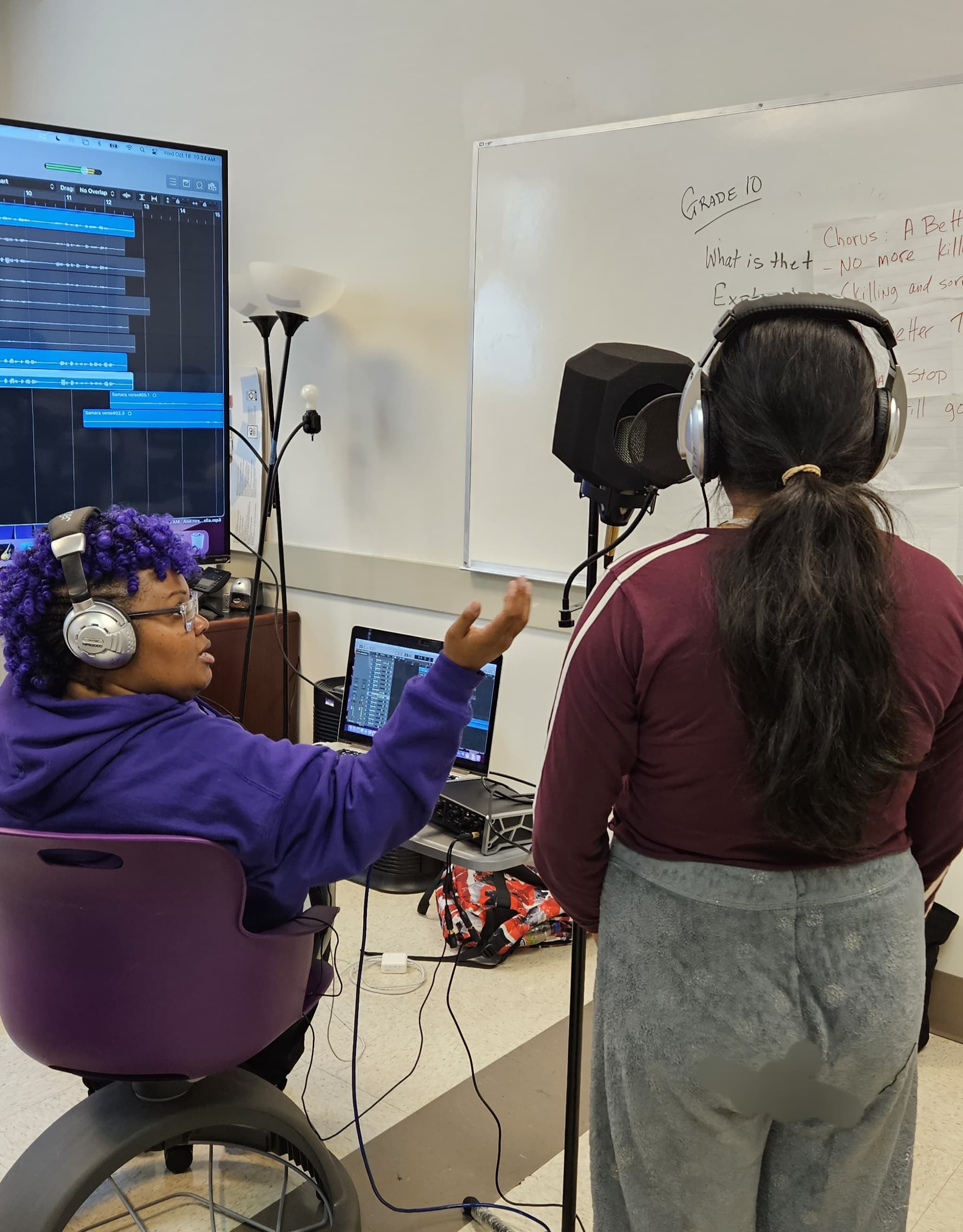 B.P.M. founder coaching a student recording vocals in a classroom
