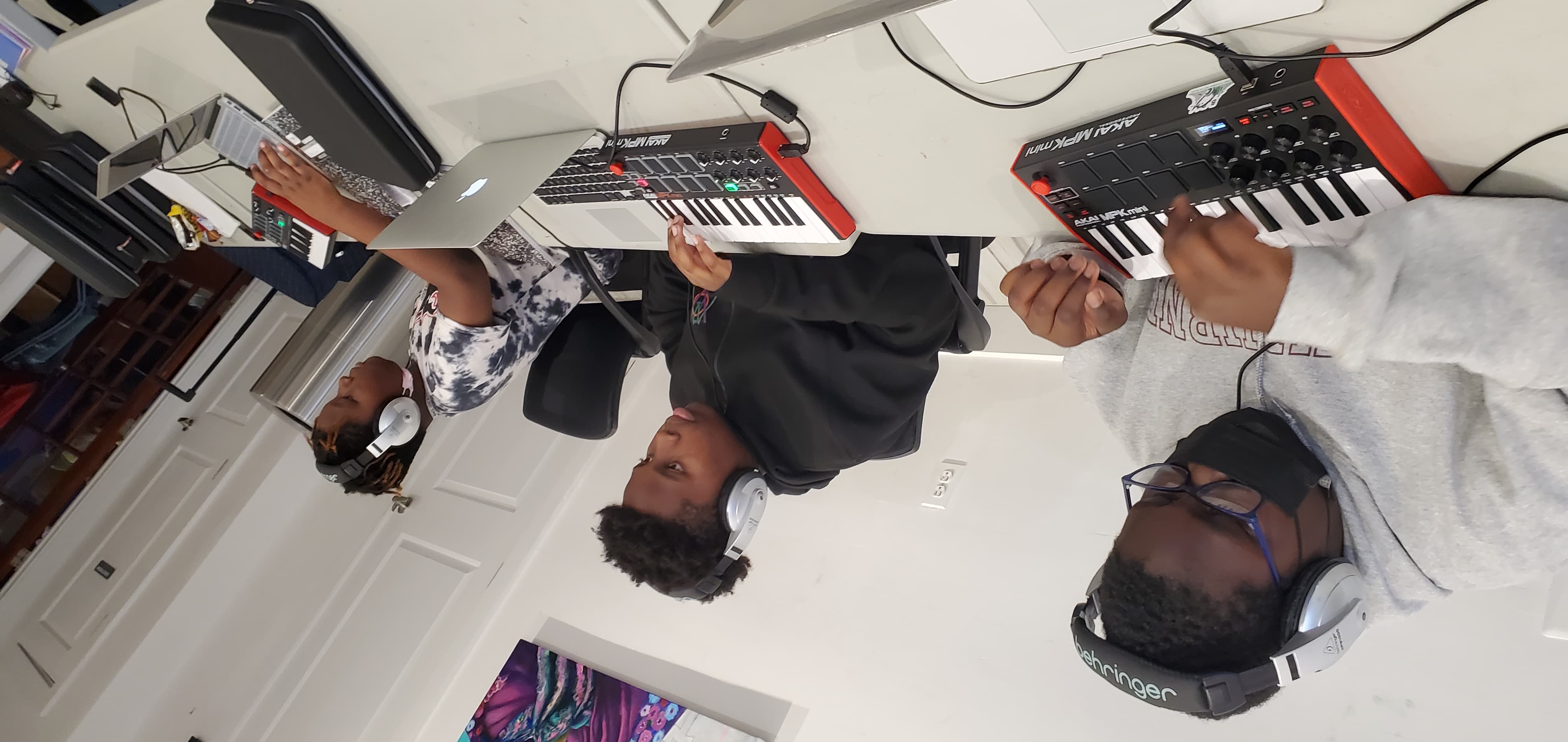 Kids creating instrumental music on laptops